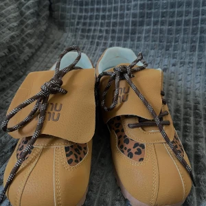 Bruna sneakers med leopardmönster - Ett par sneakers i brunt vegläder med leopard detaljer. Skorna har en unik design med unik snörning. Perfekt till våren - aldrig använda  Märke: oklart  Passar strl 38.5/39