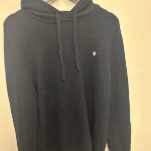Mörkblå hoodie från Morris - Säljer en stilren mörkblå hoodie från Morris. Den i i stickat material o använd ett väldigt fåtal gånger. De är storlek L men passar mig perfekt som har M.