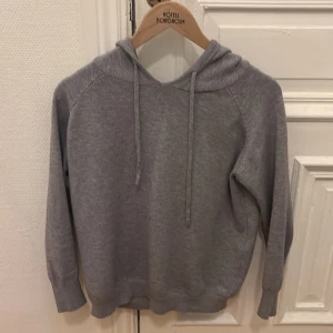 Grå hoodie - Säljer en stilren grå hoodie som är i ett bra skick har använts ett fåtal par gånger. Inga skador eller fläckar på tröjan och Den är riktigt skön. Matrial är Merino.