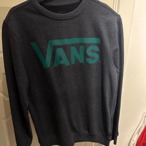 Grå sweatshirt från Vans - Säljer en stilren grå sweatshirt från Vans med deras ikoniska logga i grönt på framsidan. Använd Max tre gånger