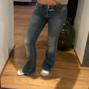 Blå bootcut jeans, low waist  - Snygga blå bootcut jeans från diesel industry med en snygg blekare färg ner längst benen (en lätt tvättad look). De är använda fåtal gånger. Dessa är i storlek 24/30, men passar folk med större eller mindre midjemått då de har så du kan spänna inuti i midjan. 