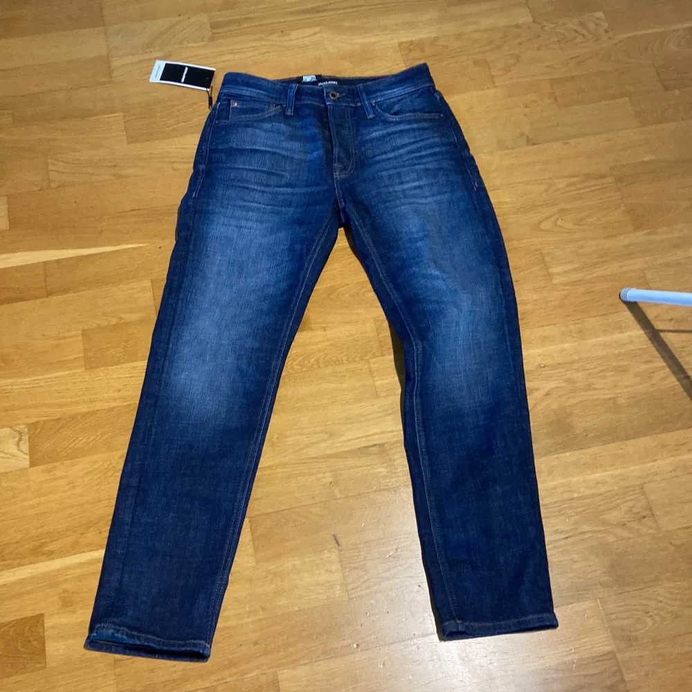 Snygga blå jeansbyxor med normal passform och klassisk femficksdesign. De har en knappgylf och är perfekta för en avslappnad stil. Passar bra till både t-shirt och skjorta.. Farkut & Housut.