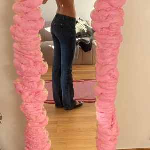 Blå jeans med stjärndetaljer - Snygga blå jeans med stjärndetaljer och nitar på fickorna. Byxorna har en bootcut-stil och är lågmidjade, vilket ger en trendig look. Perfekta för att ge din outfit lite extra edge.