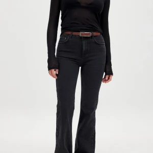 Svarta bootcut jeans - Snygga svarta bootcut jeans med hög midja. Perfekta för en stilren look. De har en klassisk femficksdesign och är tillverkade i ett bekvämt denimtyg.