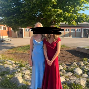 Vinröd långklänning från Goddiva - Säljer min balklänning som endast är använd en gång. Den är i mycket fint skick och går ner till marken med klackar för mig som är 165. Den har slits och en dold dragkedja i ryggen.