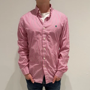 Rosa/ vitrandig skjorta från Morris - Rosa/ vit randig skjorta från Morris || Storlek M || skjortan är i bra skick, däremot missfärgad i nacken som syns på bild 3 || mitt pris 399kr || modellen på bilden är 170cm och väger 60kg || tveka inte på att höra av dig vid frågor eller funderingar 