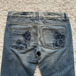 Fina vero Moda jeans - Säljer mina jättefina Jeans från vero Moda med blå broderier på då de tyvärr är lite för små på mig Innerbenslängd: 80cm Midja rakt över: 41cm (de är väldigt lågmidjade) Kontakta gärna för fler bilder eller frågor💗 pris kan alltid diskuteras!