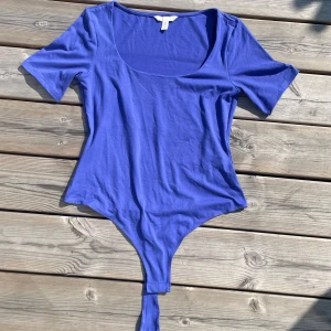 H&M blå body  - Säljer en super snygg blå body ifrån h&m. Den är slutsåld överallt och är i nyskick. Storlek s❣️