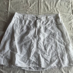 Vit kjol från Mabalder - En vit kjol från Rabalder i storlek XL. Kjolen har en enkel design med knappar framtill och är tillverkad i ett lätt och bekvämt material.