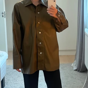 Brun jacka i skinnimitation  - Jackan är i nyskick då den aldrig är använd. 