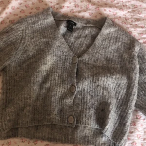 Söt grå stickad kofta med 3/4 armar🫶🏻 - En grå stickad kofta med tre knappar framtill. Koftan har en v-ringad hals och 3/4 ärmar. Aldrig använd!!!💗