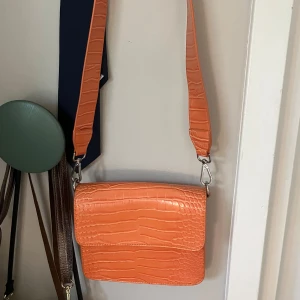 Orange axelväska - Fin orange axelväska från HVISK B: 21cm H:18cm D:5cm