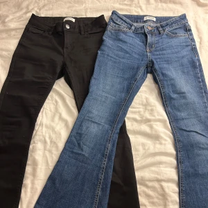 Lågmidjade jeans (svart o blå) - Säljer två par jeans (en svart och en blå) i modellen ”Freja” som är utsvängda och Lågmidjade, båda är i storlek 146