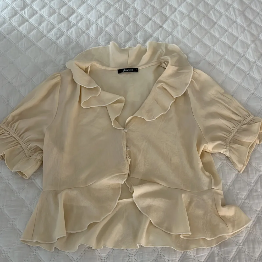 Jättesöt gul/beige färgad blus från Gina Tricot! Aldrig använd därav inga defekter🤍 Den är i stl L men passar som en S-M. Hör av er vid frågor eller fler bilder!. Blusar.