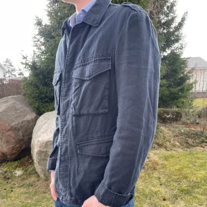 Vintage Armani Jeans linne field jacket - En fin linne-jacka från Armani, perfekt för sommaren eller våren, som inte kommer till användning. Jackan har tecken på användning och är en aning solblekt men är övrigt i bra skick.  Vid eventuella frågor är det bara att kontakta mig här på Plick!