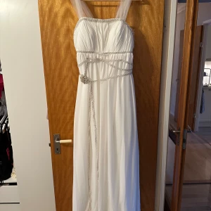 Brudklänning  - Säljer min brudklänning.Den är fantastiskt fin men har lite skavanker efter en lång dag.Det glittriga bandet har trissat upp sig på ett par ställen är du  händig kan du fixa detta.Extra band medföljer.Även en sjal,väska och garderob.Behövs tvättas.