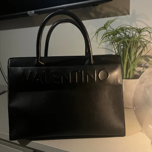 Valentino väska - En handväska från Valentino (by mario valentino) i fint skick. Säljer pga kommer inte till användning. Mitt pris: 1500 kronor