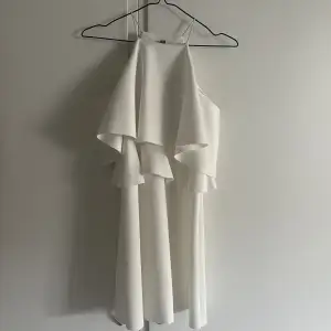Superfin vit kort klänning. Passar perfekt till ex. studenten eller skolavslutning. Endast använd en gång. Kan bäras på två olika sätt, se bilder. 