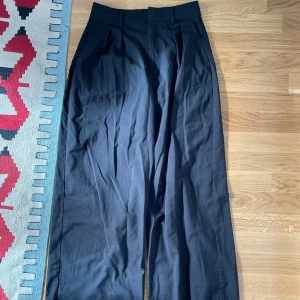 Kostymbyxor - Svarta kostymbyxor från Gina. Strl 34 men passar också 36. Vida ben och mod waist.
