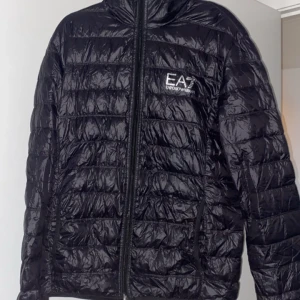 EA7 jacka - Den är i bra skick förutom en liten skada på sidan typ nere vid fickan som ni kan se på sista bilden, pris kan diskuteras 