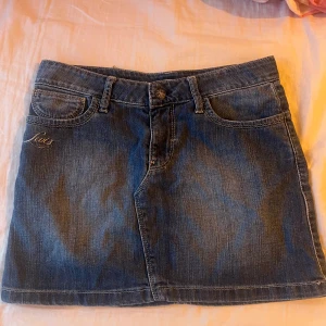 Kort jeanskjol  - Jeanskjol från Levis, köpt second hand och tyvärr för liten.  En röd fläck i vänstra hörnet, men den tänker man inte på!  Står ingen storlek men skulle säga runt XS.  Midja rakt över: 36,5 cm  Längd: 33 cm 