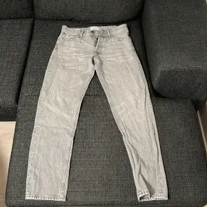 Det är par gråa jeans från Jack and Jones. De är perfekta till någon som gillar att bära lite mer straight/ baggy jeans. Skick 8/10