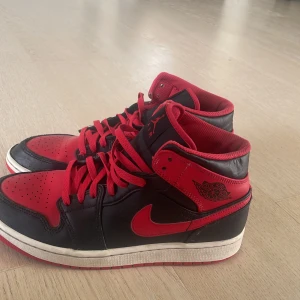 Jordan 1 ”bannad” Mid  - Säljer mina jordans då dem blivit för små och inte orka användas köpte dem för ”2 399” 2023, har inte använt så mycket men har lite små skrap märken och behövs köpas nya snören annars är allt som de ska, Mitt pris 999 priset kan diskuteras 