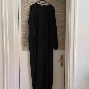 Säljer denna svarta abaya i storlek 60, tillverkad i jazz-material, köpt från Luudecollection. Skicket är något mindre än perfekt, knappen sitter kvar men lappen är sönder på ena sidan. Det går att sy fast om man vill. Pris: 150kr