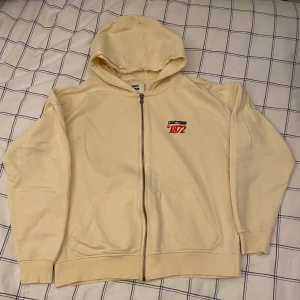 Zip upp med tryck - Den är i väldigt bra skick liten fläck på luvan, annars är den som ny, väldigt snyggt tryck, den är unisex från Zalando köpt för ca 700kr