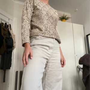 Blommig topp - Blommig topp i guldbeige färg och lite mesh-liknande material, superfin till sommaren! 