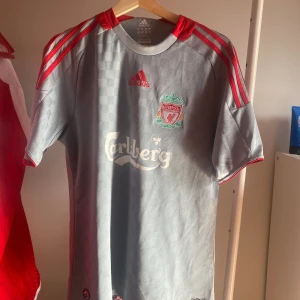 Liverpool tröja - Fint skick förutom en jätte litem spricka i sponsorn. Bara att fråga på vid frågor!