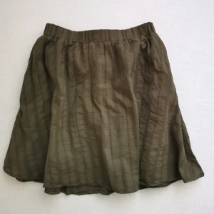 Kjol med broderi - Olivgrön kjol med broderi i mycket bra skick. Använd ca 2ggr.