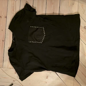 T-shirt  - Super snygg tshirt med en ficka med nitar. Lite kortare modell