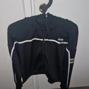 Tröja stronger - Tröja med luva. Dragsko på sidorna. Från stronger. Stl L