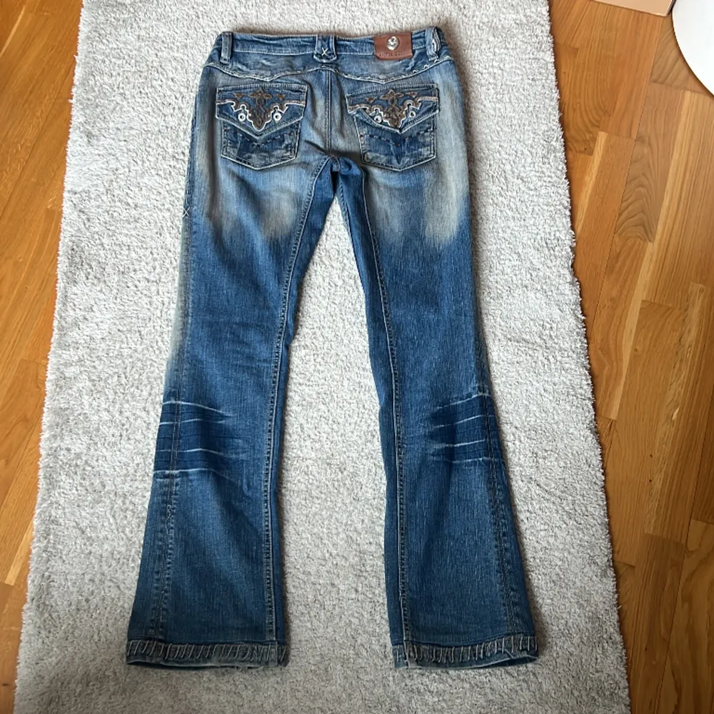 Ascoola vintage lågmidjade bootcut jeans med snygga detaljer. Lite slitning längst ner på vänster ben.  Midjemåttet är ungefär 39 cm och innerbenslängden är 79 cm💓Lite lösa på mig som vanligtvis är strl 36. Kan skicka mer bilder vid begäran💘. Jeans & Byxor.