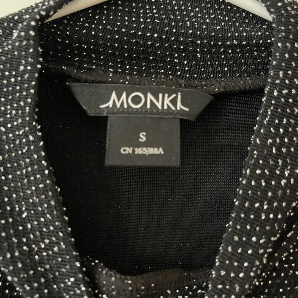 Glittrig svart t-shirt från Monki i storlek S. Turtleneck krage. Stretchigt material. Använd ett fåtal gånger, i fint skick. Bara att fråga om det är något du undrar! Kan mötas på Järntorget i Göteborg eller skicka, köparen står för frakt.. Toppar.