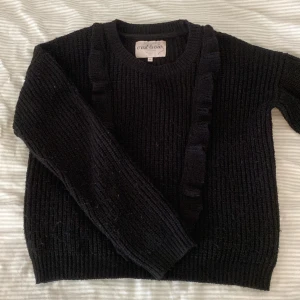 Svart stickad tröja  - Säljer denna svarta stickade tröjan med volang