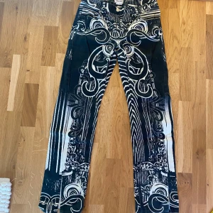 JEANS  - Grön/svarta Jeans från WEEKDAY. Modell ”los painted trousers” Storlek 36. Tunna och lite stretchiga i materialet. Låg/Mellan midja. Raka men med lite lite utåtsvängt i botten. Slits på framsida ben. Innerbenslängd ca 77cm. Modellen i bilden är 160cm 