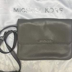 Superfin väska från Michael Kors i grått med flera fack varav ett med dragkedja. Höjd 17 bredd 22