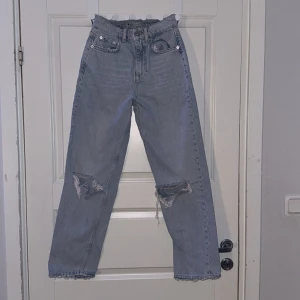 Jeans med hål i - Blåa jeans från ginatricot med hål i. Aldrig använd utan bara testad. Storlek 32/Xs.