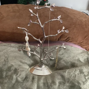 Smyckeställning  - Har ett silver trä som man kan hänga armband eller halsband, ringar mm. Jätte fin. Kan hänga ganska mycket på trät. Förstås använd. Hängt mina smycken på, men tycker annars att de inte är något fel på den. Bra skick. Kan va lite dammig. Säljer för 90