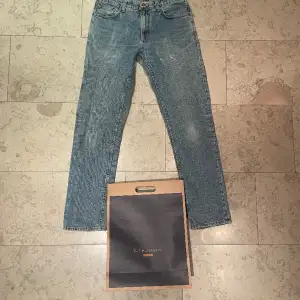 Ett par ”Friendly blue” Gritty Jackson jeans från Nudie jeans Co. - Lagade vid vänster fick (bild 2) och mellan bena (bild 3). Nypris: 1 600kr Man kan laga jeansen gratis i alla nudie butiker.