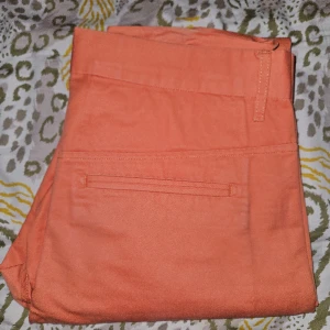 Orange byxor från Filippa K - Säljer ett par fina herrbyxor från Filippa K. Storlek 48 och väldigt sparsamt använda.