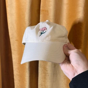Vit keps - Minimalistisk keps med en blomma på:) Inge fel på den:) tyvärr syns det på insidan att den är använd:/ har försökt få bort de jag kunde få bort:) dm vid frågor:)