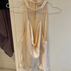 Satin partytop  - En festlig top i satin. Öppen framtill, enkel att bära med en fin och bekväm krage!