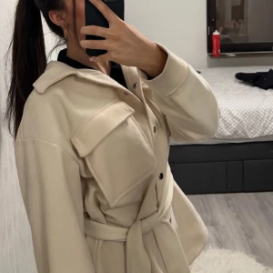 Beige kappa - Säljer min beiga kort kappa (utan skärp). I otroligt fint skick!! Säljer då den tyvärr inte kommer till användning. 