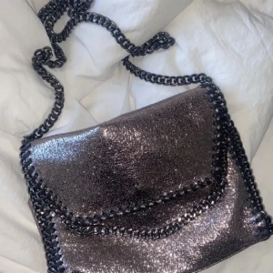 Glittrig Stella McCartney liknande väska - Jättesöt Stella McCartney liknande handväska med lång band som du kan vika in så det blir kortare!