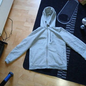 Sailracing bowman zip - En väldigt tvättad Sailracing hoodie som köptes för 1500kr förra året, Ser helt normal ut förutom där nere vid kanten där ser man att den e tvättad. Säljer billigt då den e för liten😀