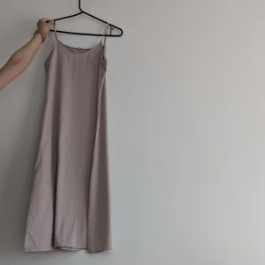 Strap klänning - Ingen dragkedja, man kan dra över den utan. Fint med skärm för att framhäva midjan. 