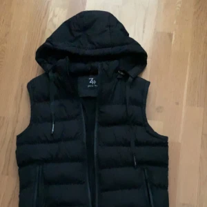 Väst med luva - Hej säljer min väst med luva. Väldigt skön stil på den. Köpte på amazon men använder sällan. Liten skada på sidan!